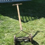 A push mower on a nicely cut green lawn