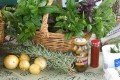 February Harvest - Sustainable Fawkner Food Produce Swap image by Takver (flickr) A basket of bunches of basil on a table with few fruit, sprigs of rosemary, and bottled goods in front of the basket.