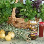 February Harvest - Sustainable Fawkner Food Produce Swap image by Takver (flickr) A basket of bunches of basil on a table with few fruit, sprigs of rosemary, and bottled goods in front of the basket.