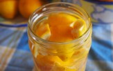 quartered lemons emersed in white vinegar in a jar