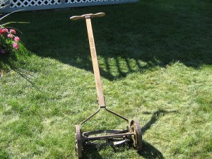 A push mower on a nicely cut green lawn