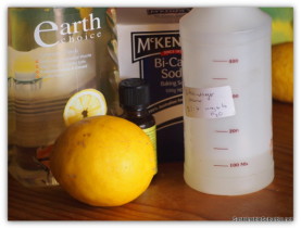 earth choice dish soap, a lemon, tea tree oil, baking soda and a spray bottle of homemade lemon citrus cleaner