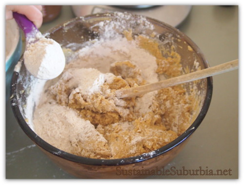 Mixing bowl with a small hand adding in some flour