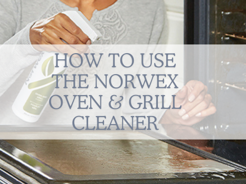 How to use the Norwex Oven & Grill Cleaner. image shows an open oven door, with hand holding a bottle of Norwex oven and grill cleaning and spraying the door.