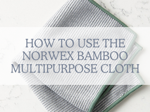 How to use the norwex bamboo multipurpose cloth. image shows a grey cloth with green piping around the edges, folded into quarters.